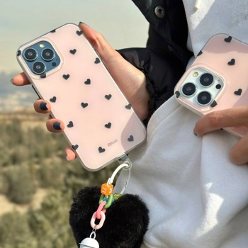 قاب آیفون Heart White Pom صورتی با قلب‌های مشکی و آویز قلبی خزدار مشکی